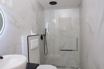 a bathroom with a shower with a toilet and a sink at Your Escape Home in Praia in Praia