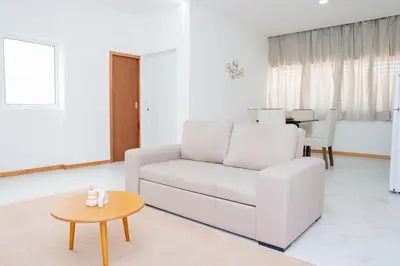 a white living room with a white couch and a table at Your Escape Home in Praia in Praia