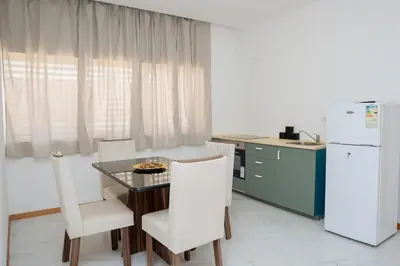 a kitchen with a table and chairs and a refrigerator at Your Escape Home in Praia in Praia