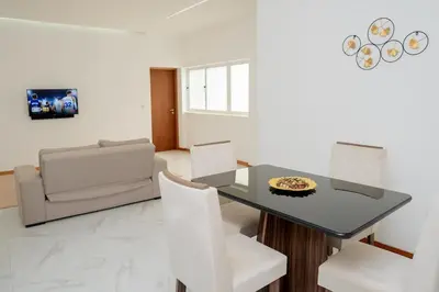 a dining room with a black table and white chairs at Your Escape Home in Praia in Praia