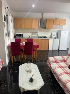 a kitchen with a table and red chairs and a kitchen with a table at MeM Apartment in Praia