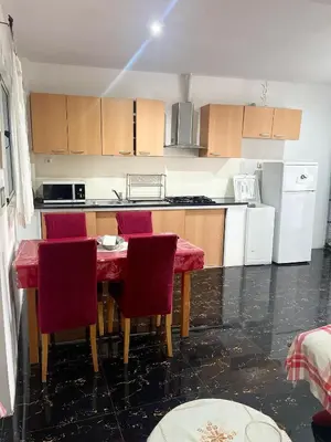 a kitchen with a table and red chairs in it at MeM Apartment in Praia