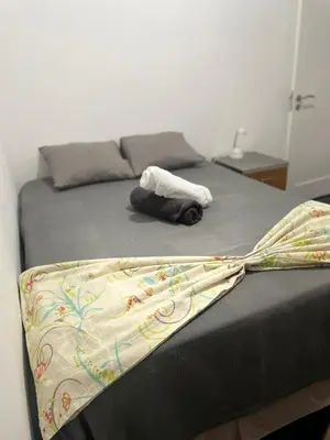 a bed with a blanket on top of it at MeM Apartment in Praia