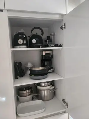 a kitchen pantry with pots and pans on shelves at Boa Mindelo Azul in Mindelo