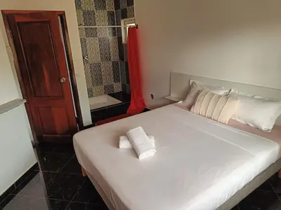 a bedroom with a white bed with two towels on it at Casa Miami in Tarrafal