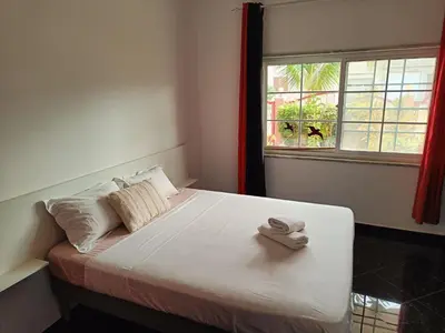 a bed with two towels on it in a room with a window at Casa Miami in Tarrafal