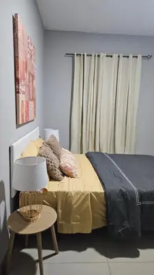 a bedroom with a bed and a table with a lamp at Palmarejo Cozy Retreat in Praia