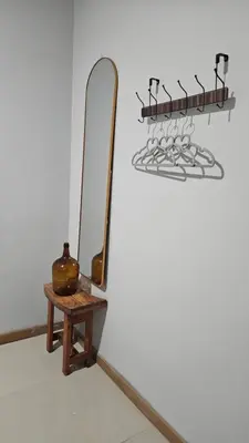 a mirror and a table with a vase on a wall at Palmarejo Cozy Retreat in Praia