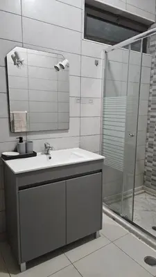 a bathroom with a sink and a shower at Palmarejo Cozy Retreat in Praia