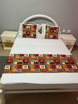 a bed with a colorful quilt on it at KÁ Rui in Santa Maria