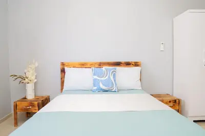 a bedroom with a bed with a wooden headboard at J Martins Apart T11 Tarrafal in Tarrafal