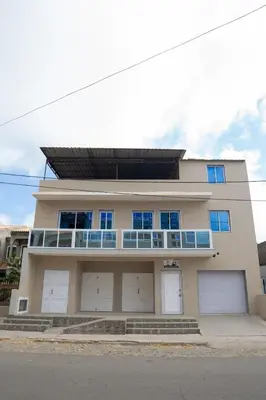 a house with four garage doors and a balcony at J Martins Apart T11 Tarrafal in Tarrafal
