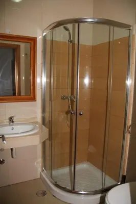 a bathroom with a shower and a sink at Delfim Apartamentos in Praia