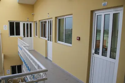 a hallway of a building with stairs and windows at Delfim Apartamentos in Praia