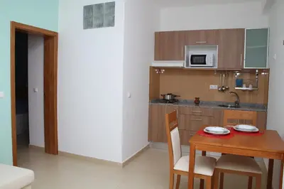 a small kitchen with a table and a microwave at Delfim Apartamentos in Praia