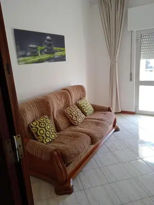 a brown couch sitting in a living room at Conforto de um Lar in Ponta do Sol