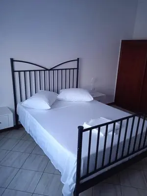 a bed with white sheets and pillows in a bedroom at Conforto de um Lar in Ponta do Sol