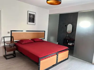 a bedroom with a large bed with a red blanket at Nos Cantin Ensuite Bedroom in Mindelo