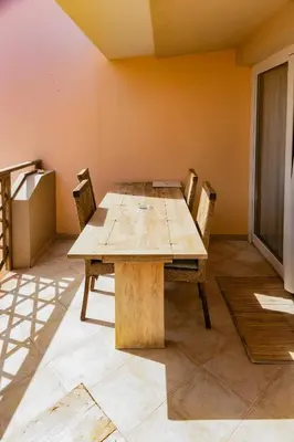 a wooden table and chairs in a room at Aparthotel Tropical Bounty Beach T3 in Santa Maria