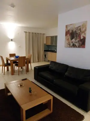 a living room with a black couch and a table at Tity Apartments T1 - Perfect Stay on your Holiday in Santa Maria