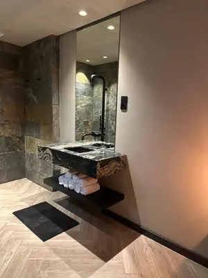 a bathroom with a stone sink and a mirror at Santiago Apartment in Mindelo