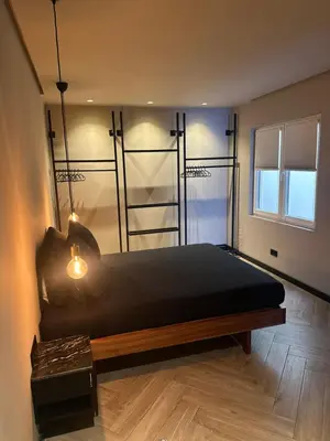 a bedroom with a bed with a wooden floor and a window at Santiago Apartment in Mindelo