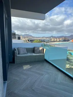 a living room with a couch on a balcony at Santiago Apartment in Mindelo