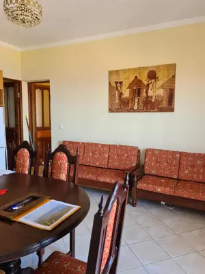 a dining room with couches and a table at Djarfogo house in São Filipe