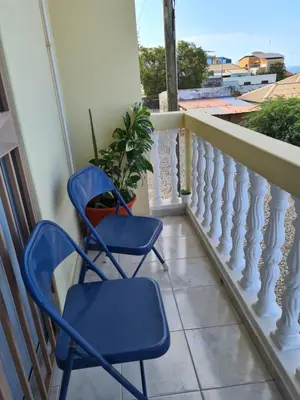 two chairs on a balcony with a plant at Djarfogo house in São Filipe