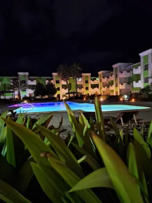 a pool at night with buildings in the background at Djadsal Moradias in Santa Maria