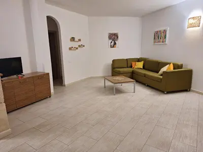 a living room with a couch and a tv at Djadsal Moradias in Santa Maria