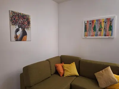 a living room with a couch and a painting at Djadsal Moradias in Santa Maria