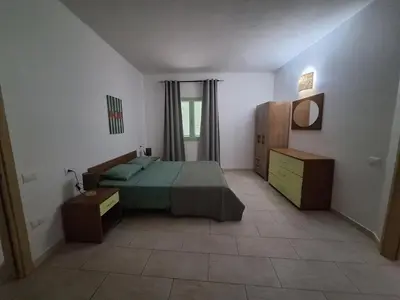 a bedroom with a bed and a dresser in it at Djadsal Moradias in Santa Maria
