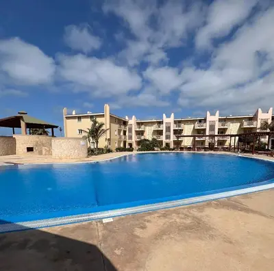 a large swimming pool in front of a building at Tropical Morna in Santa Maria