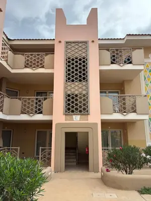 an apartment building with a pink at Tropical Morna in Santa Maria