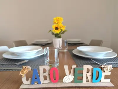 a table with plates and glasses and a sign that saysario at TOP POOL VIEW - Tropical Apt B11 - PointingCaboVerde in Santa Maria