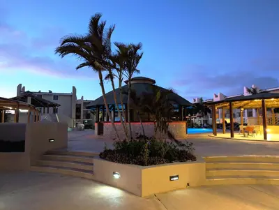 a resort with palm trees and a building with lights at TOP POOL VIEW - Tropical Apt B11 - PointingCaboVerde in Santa Maria