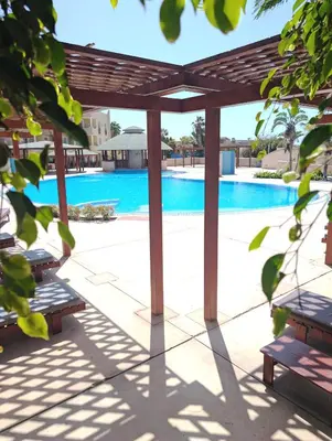 a pergola and benches next to a swimming pool at TOP POOL VIEW - Tropical Apt B11 - PointingCaboVerde in Santa Maria