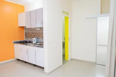a kitchen with white cabinets and a sink at J Martins ApartHotel in Tarrafal
