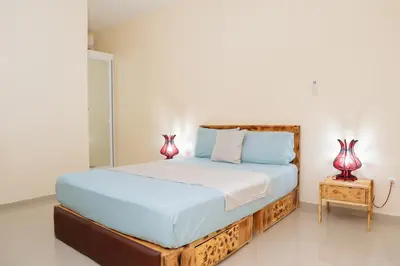 a bedroom with a wooden bed with two vases on a table at J Martins ApartHotel in Tarrafal