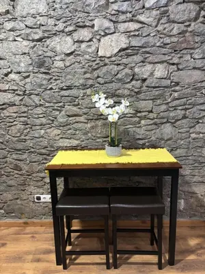 a yellow table with a vase of flowers on it at Techas City Center Luxe Suites in Praia