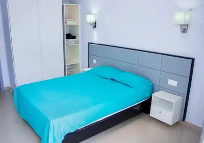 a bedroom with a bed with a blue bedspread at Morabeza & Mar in Porto Novo