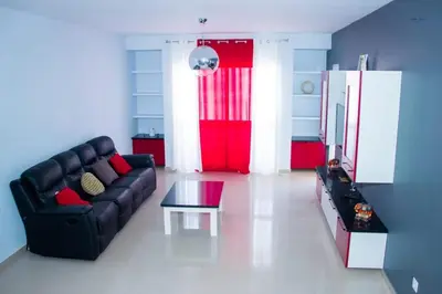 a living room with a black couch and a red door at Morabeza & Mar in Porto Novo