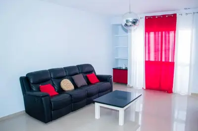 a living room with a black couch and a table at Morabeza & Mar in Porto Novo