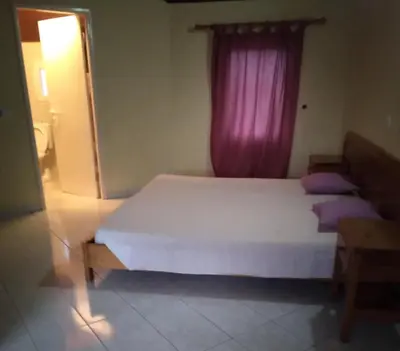 a bedroom with a large bed with a pink window at Coral Reef in Santa Maria