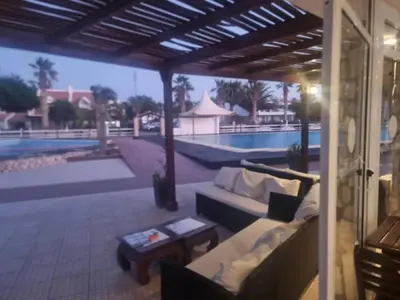 a patio with a couch and a table and a pool at Coral Reef in Santa Maria