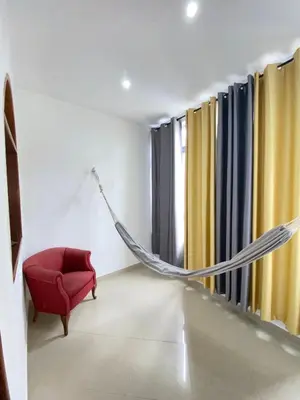 a hammock in a room with a red chair and a window at Mar Azul Tarrafal APARTMENT in Tarrafal