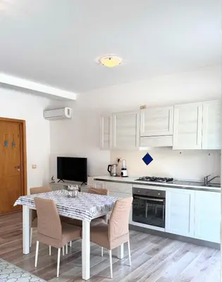 a kitchen with white cabinets and a table and chairs at Wave Studio in Sal Rei