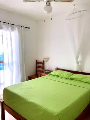 a bedroom with a green bed and a window at Beachapartment fully serviced in Sal Rei