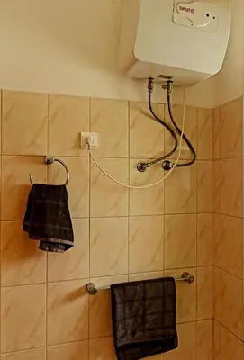 a shower with two black towels hanging on a wall at Capo Verde Club - Ca Francesca in Santa Maria